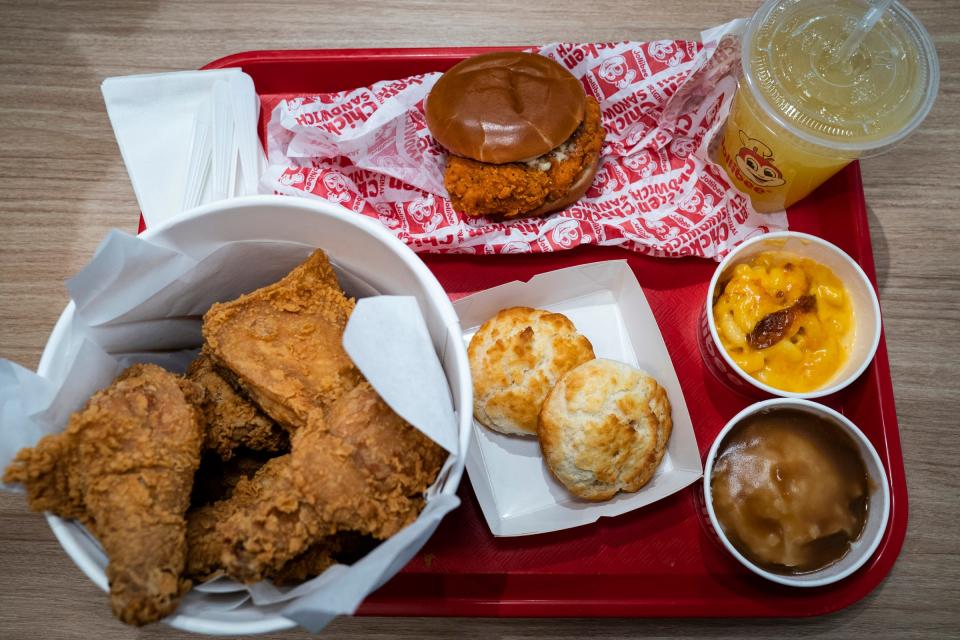 A tray of menu items including Chickenjoy bucket of chicken, biscuits, mashed potatoes and gravy, mac and cheese and Pineapple Quencher at the new Jollibee fast food restaurant in Sterling Heights on Thursday, Jan. 11, 2024, the restaurant will open on Friday, Jan. 12, 2024.