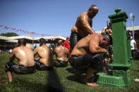 An exhausted wrestler tries to cool off after he competed on the second day of the 660th instalment of the annual Historic Kirkpinar Oil Wrestling championship, in Edirne, northwestern Turkey, Saturday, July 10, 2021.Thousands of Turkish wrestling fans flocked to the country's Greek border province to watch the championship of the sport that dates to the 14th century, after last year's contest was cancelled due to the coronavirus pandemic. The festival, one of the world's oldest wrestling events, was listed as an intangible cultural heritage event by UNESCO in 2010. (AP Photo/Emrah Gurel)