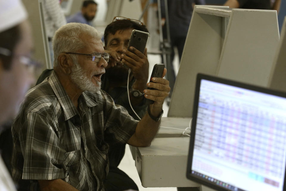 Pakistani brokers react while they monitor Index on their mobile phone at at the Pakistan Stock Exchange (PSE), in Karachi, Pakistan, Friday, June 24, 2022. Pakistan's stock market suddenly fell by three percent on Friday, shortly after the government of recently elected Prime Minister Shahbaz Sharif suddenly announced the imposition of additional taxes on the corporate and banking sector in an effort aimed at stabilizing the country's fledgling economy. (AP Photo/Fareed Khan)