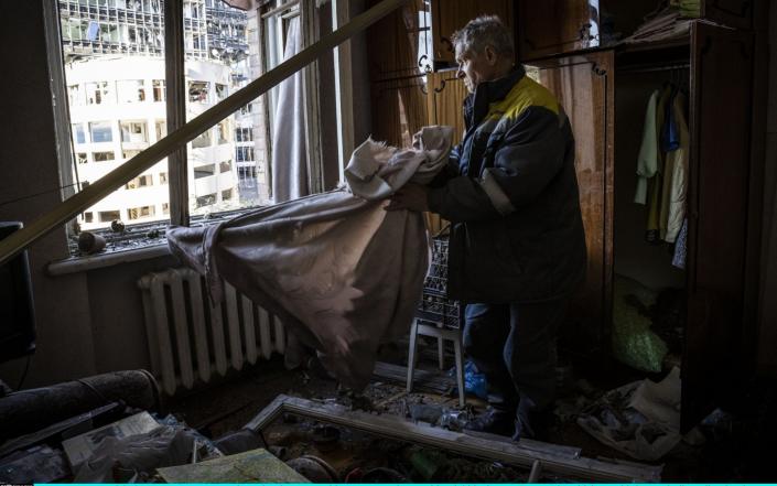 A man examines the damage to his apartment in a residential block which was hit by a missile strike the day before near Kyiv's main train station - Ed Ram/Getty Images Europe