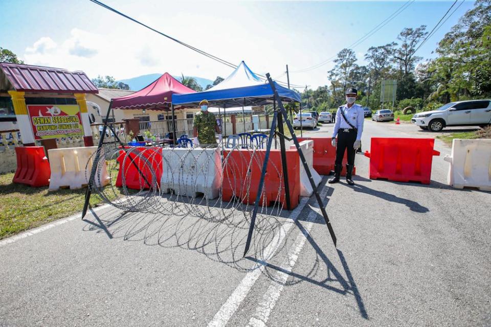 Traffic police and RELA personnel man a roadblock in Sungai Lui, Hulu Langat on April 1, 2020. — Picture by Hari Anggara