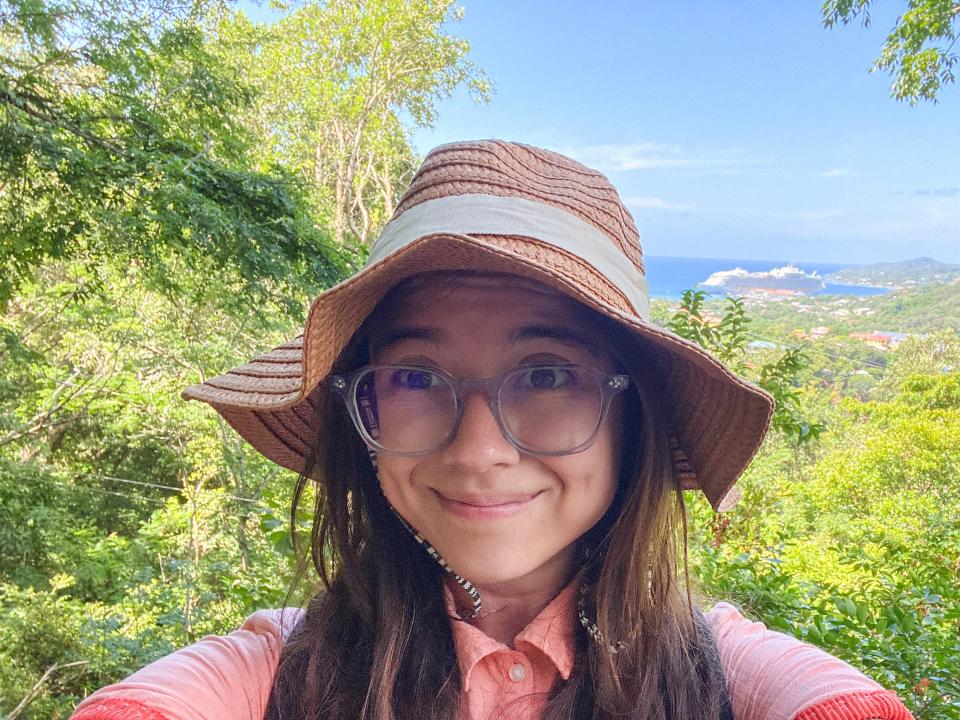 The author in front of trees and the world's largest cruiseship in the background, docked in roatan