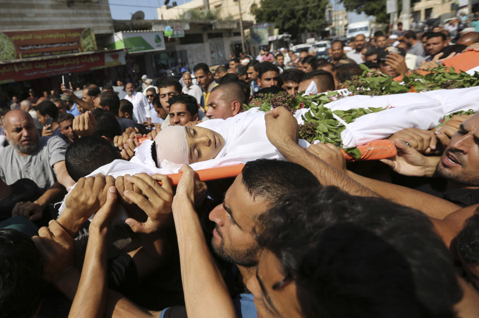 FILE - Mourners carry the body of 11 year-old boy, Nasser Musabeh, who was shot and killed by Israeli troops during a protest at the Gaza Strip's border with Israel, during his funeral in Khan Younis, southern Gaza Strip, Saturday, Sept. 29, 2018. Rights groups said Thursday. Dec. 2, 2021, that Israel failed to investigate shootings that killed more than 200 Palestinians and wounded thousands at violent protests along the Gaza frontier in recent years, strengthening the case for the International Criminal Court to intervene. (AP Photo/Sanad Abu Latifa, File)