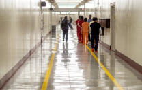 In this Nov. 15, 2019, photo, detainees walk through the halls at the Stewart Detention Center, in Lumpkin, Ga. The rural town is about 140 miles southwest of Atlanta and next to the Georgia-Alabama state line. The town’s 1,172 residents are outnumbered by the roughly 1,650 male detainees that U.S. Immigration and Customs Enforcement said were being held in the detention center in late November. (AP Photo/David Goldman)