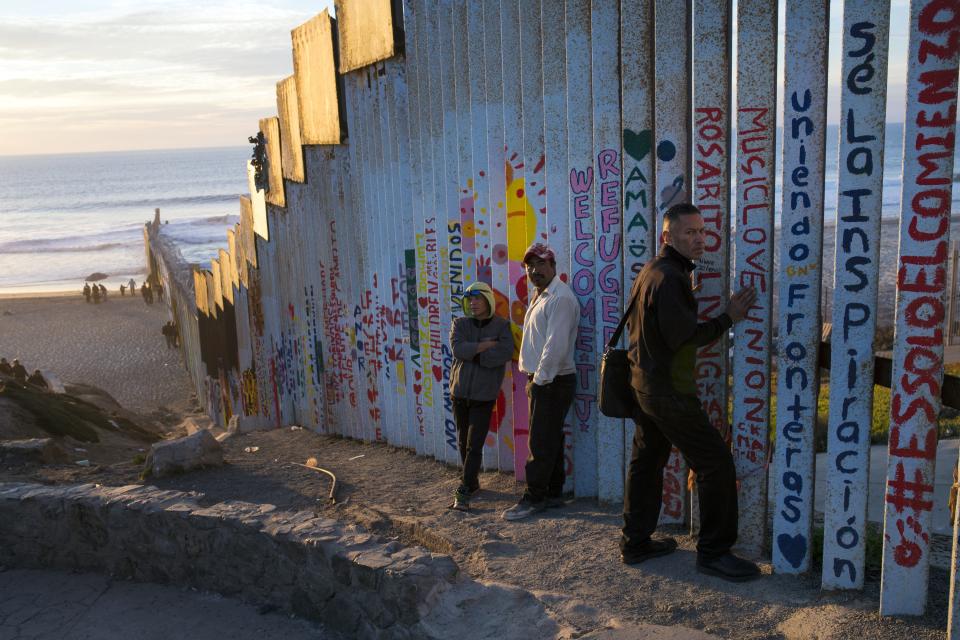 People hang out at the Mexican side of the border structure that separates Mexico from the U.S., at the Pacific Ocean, Tijuana, Mexico, Friday, Nov. 16, 2018. As thousands of migrants in a caravan of Central American asylum-seekers converge on the doorstep of the United States, what they won't find are armed American soldiers standing guard. (AP Photo/Rodrigo Abd)