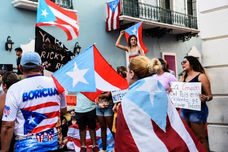 Demonstrators chant and wave Puerto Rican flags during the fourth day of protest calling for the resignation of Governor Ricardo Rossello in San Juan