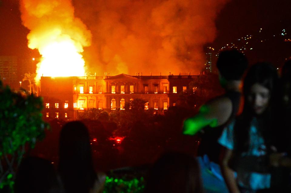 People watch as a massive fire engulfs the National Museum in Rio de Janeiro in Brazil on Sept. 2, 2018.