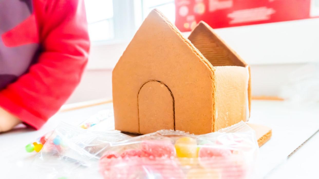 assembling a gingerbread house at christmas time, with icing sugar as the bonding 'glue' a classic holiday activity, making a decoration and dessert