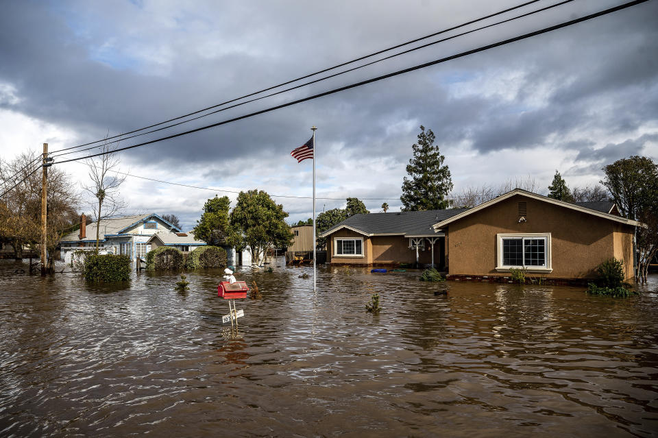 FILE - Floodwaters surround homes on Thornton Road in Merced, Calif., as storms continue battering the state on Tuesday, Jan. 10, 2023. In California, only about 230,000 homes and other buildings have flood insurance policies, which are separate from homeowners insurance. (AP Photo/Noah Berger, File)