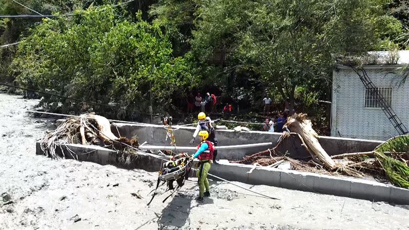 廬山溫泉成孤島，消防署特搜人員架繩索運送災民。（圖／消防署提供）