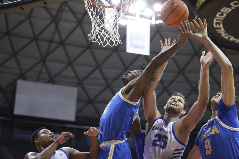 Chaminade guard Jamir Thomas, left, UCLA guard Sebastian Mack, Chaminade forward Wyatt Lowell (25) and UCLA forward Berke Buyuktuncel (9) all go for a rebound during the second half of an NCAA college basketball game Tuesday, Nov. 21, 2023, in Honolulu. (AP Photo/Marco Garcia)