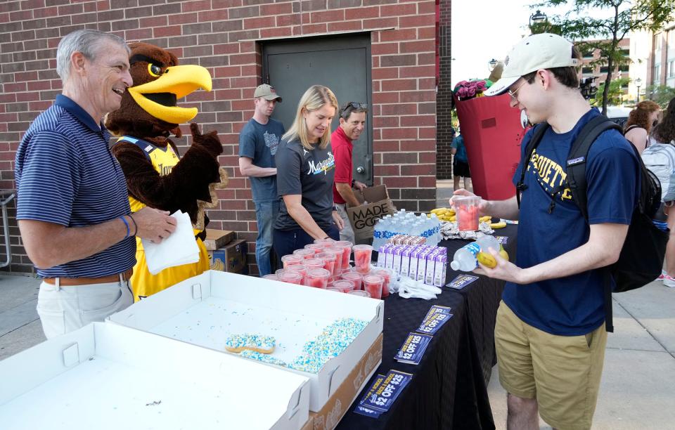 Marquette University president Michael Lovell, the Marquette University mascot, Iggy, women's basketball coach Megan Duffy and Fresh2Go Co-Owner Ted Balistreri hand out free breakfasts at Sendik's Fresh2Go on the Marquette campus.