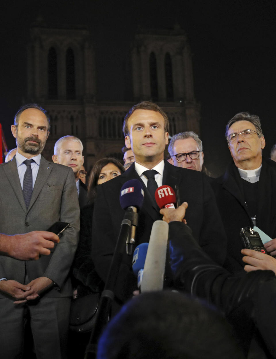 French Prime Minister Edouard Philippe, left, French President Emmanuel Macron, and Archbishop of Paris, Michel Aupetit, right, answer reporters after watching the fire at Notre Dame cathedral in Paris, Monday, April 15, 2019. A catastrophic fire engulfed the upper reaches of Paris' soaring Notre Dame Cathedral as it was undergoing renovations Monday, threatening one of the greatest architectural treasures of the Western world as tourists and Parisians looked on aghast from the streets below.(Philippe Wojazer/Pool via AP)