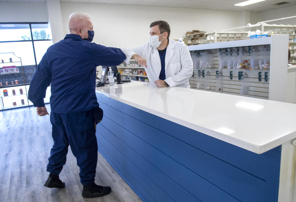 Admiral Brett Giroir, the Assistant Secretary for Health at the U.S. Department of Health and Human Services, elbow bumps Pharmacist Stacey LaBorde as the two meet at LaPharmacy in Elmwood, La., to discuss the coronavirus vaccine distribution on Wednesday, Dec. 2, 2020. (Chris Granger/The Advocate via AP)