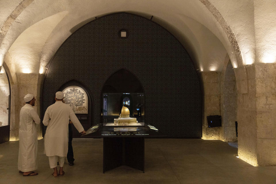 Visitors stand near a scaled model of Jerusalem's golden Dome of the Rock in a newly redesigned gallery at the Tower of David Museum in Jerusalem's Old City, Monday, May 22, 2023. Today, the former castle serves as a museum dedicated to the city’s 3,000-year history. (AP Photo/Ohad Zwigenberg)