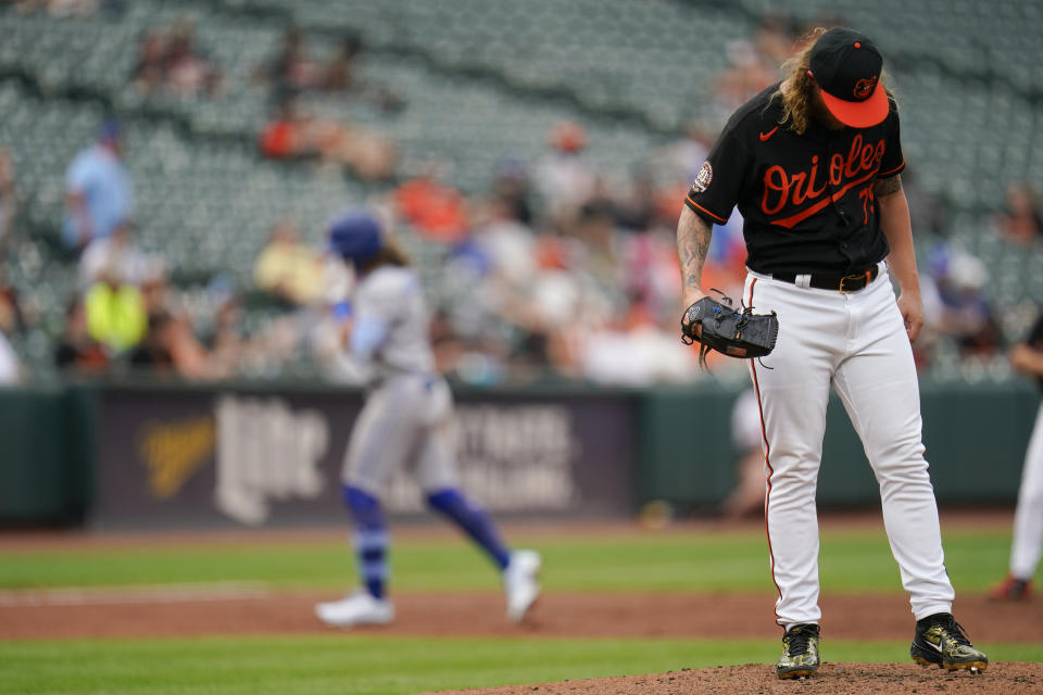 Baltimore Orioles relief pitcher Nick Vespi, right, stands on the mound as Toronto Blue Jays' Bo Bichette, left, runs the bases after hitting a three-run home run off him during the third inning of the second game of a baseball doubleheader, Monday, Sept. 5, 2022, in Baltimore. Blue Jays' Jackie Bradley Jr. and George Springer scored on the home run. (AP Photo/Julio Cortez)