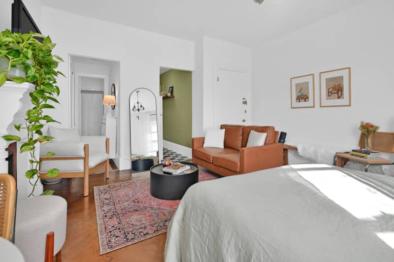 Leather couch on a rug in a studio apartment.