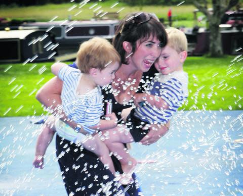 Oxford Mail: Laura Williams with sons Jack, left, and Oscar enjoy the fountains at Abbey Meadows.