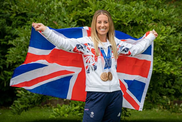 Charlotte Dujardin raises the Union flag while wearing her medals from the Tokyo 2020 Olympics