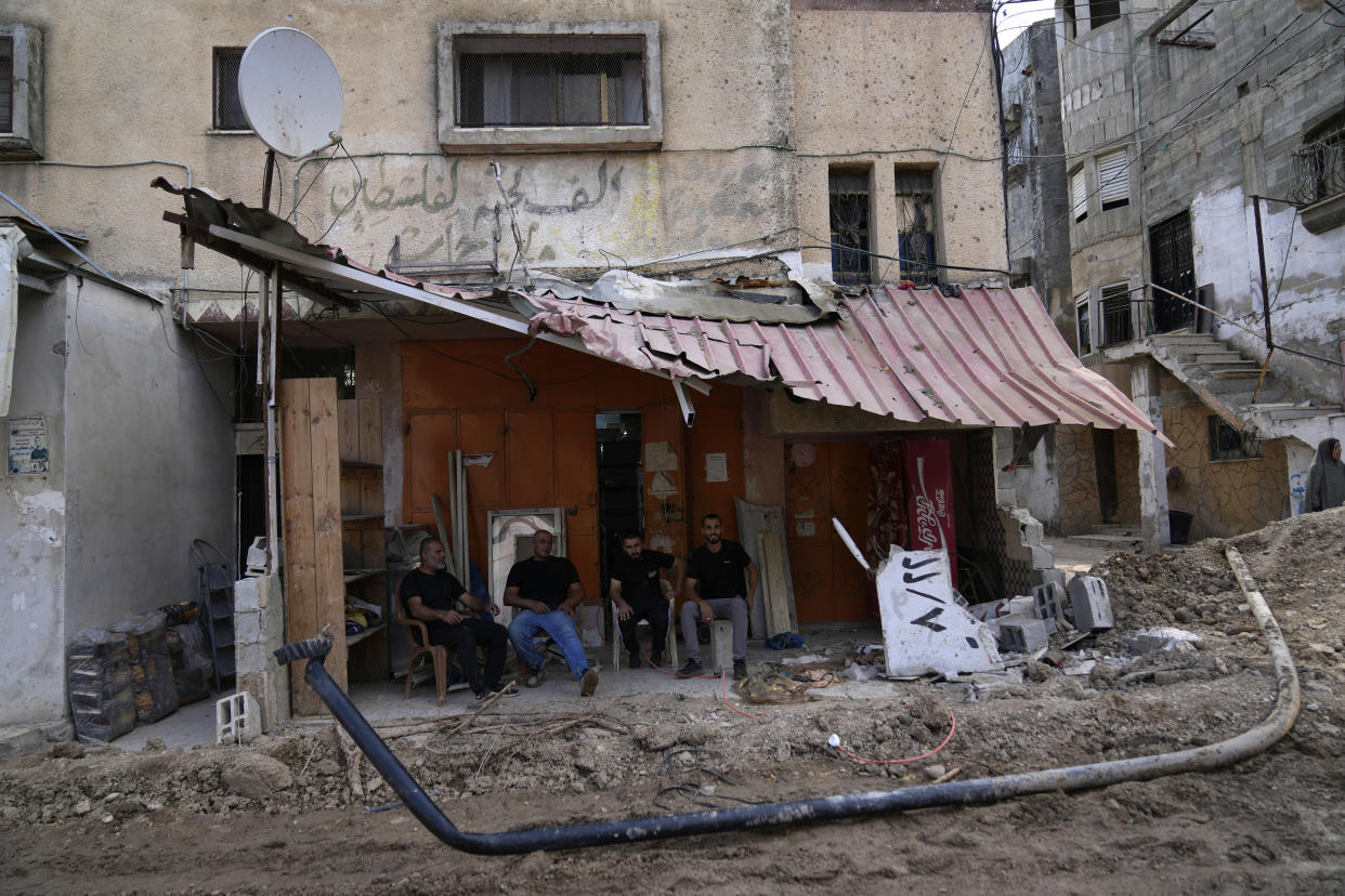 Palestinian refugees sit in front of their shops that were damaged during the Israeli army operation in the West Bank refugee camp of Tulkarem, in Tulkarem, Thursday, Sept. 5, 2024. (AP Photo/Nasser Nasser)