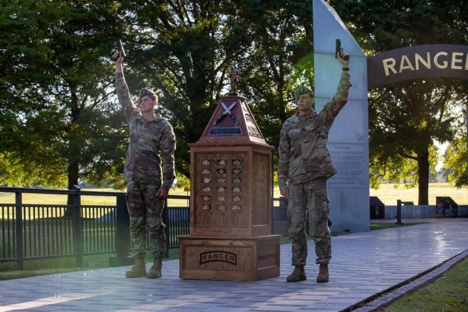 US Army 1st Lt. Andrew Winski and Sgt. Mathew Dunph holds up their SigSauer P320-M17 next to the Best Ranger Competition Trophy.