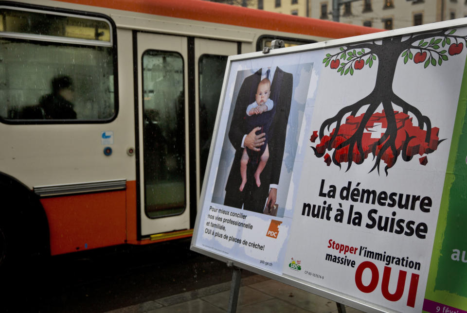 A bus passes by an election poster, center, from the nationalist Swiss People’s Party, demanding a stop for immigration to Switzerland in the center of Geneva, Switzerland, Monday, Feb. 10, 2014. The poster reads ' excess harms Switzerland'. The choice by Swiss voters to reimpose curbs on immigration is sending shockwaves throughout the European Union, with EU leaders on Monday warning the Swiss had violated the “sacred principle” of Europeans’ freedom of movement and politicians anxiously trying to gauge the vote’s impact on burgeoning anti-foreigner movements in other countries. (AP Photo/Anja Niedringhaus)