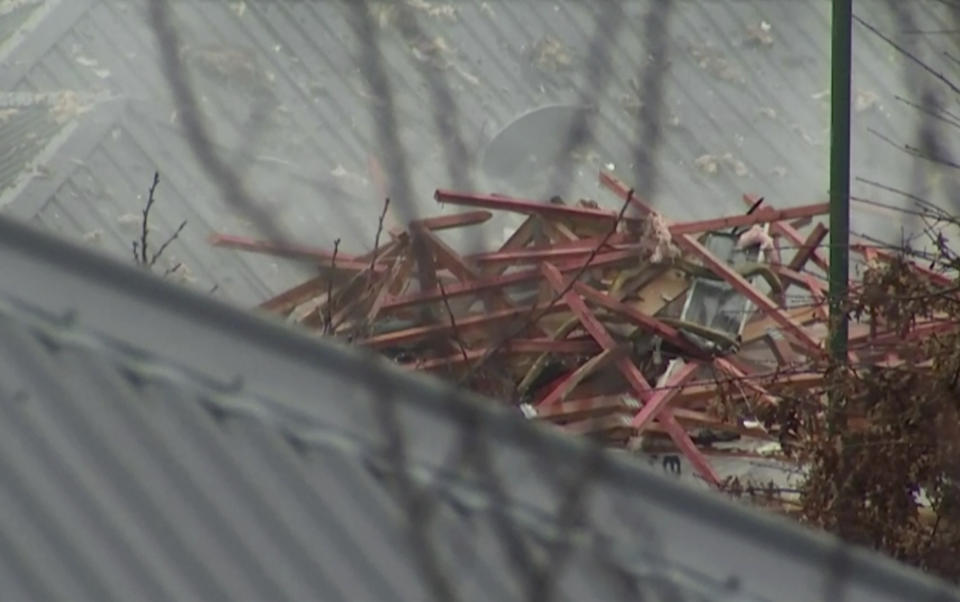 This imaged made from a video shows debris from a destroyed house on neighboring roof in Christchurch, New Zealand Friday, July 19, 2019. Several people were injured and dozens of homes evacuated in the New Zealand city of Christchurch on Friday after a huge gas explosion destroyed one home and damaged others. (TVNZ via AP)