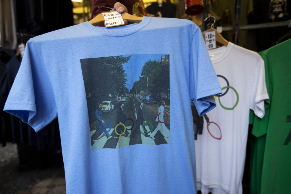 In this photo taken Monday, July 16, 2012, a t-shirt with featuring the cover photograph from the album "Abbey Road" printed on it, shows The Beatles holding Olympic rings as they walk across the zebra crossing as it sold at a London market. The guardians of the games are vigilant about protecting the integrity - and the commercial clout - of the Olympic brand. But even they can't stop the irreverent spirit of artists and craftspeople, who have responded to the games with a cheeky mix of celebration, skepticism and satire. (AP Photo/Matt Dunham)