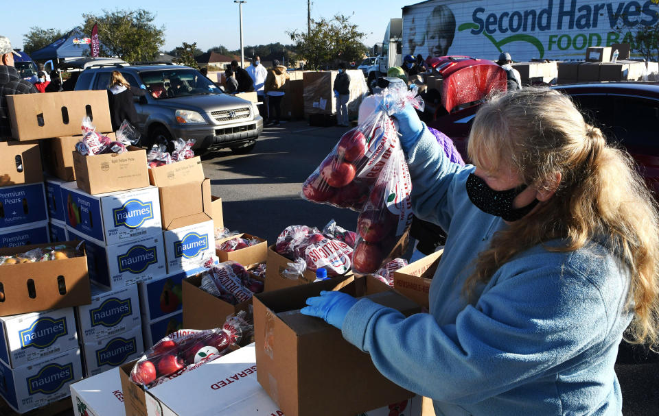 A volunteer prepares boxes of food assistance at a food distribution event in Groveland, Florida, on Dec. 9. (Photo: NurPhoto via Getty Images)