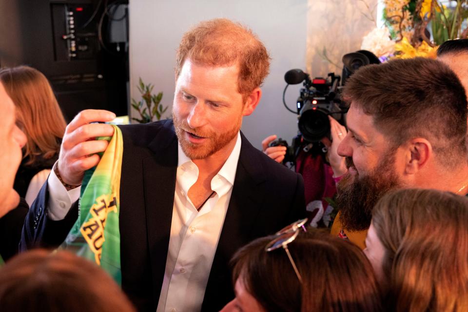 Prince Harry appears to examine the label of the swim briefs he was gifted by Team Australia at the Invictus Games to check on their size.