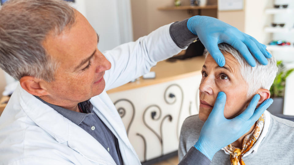 A woman receiving an eye exam from a male doctor to check for a stye