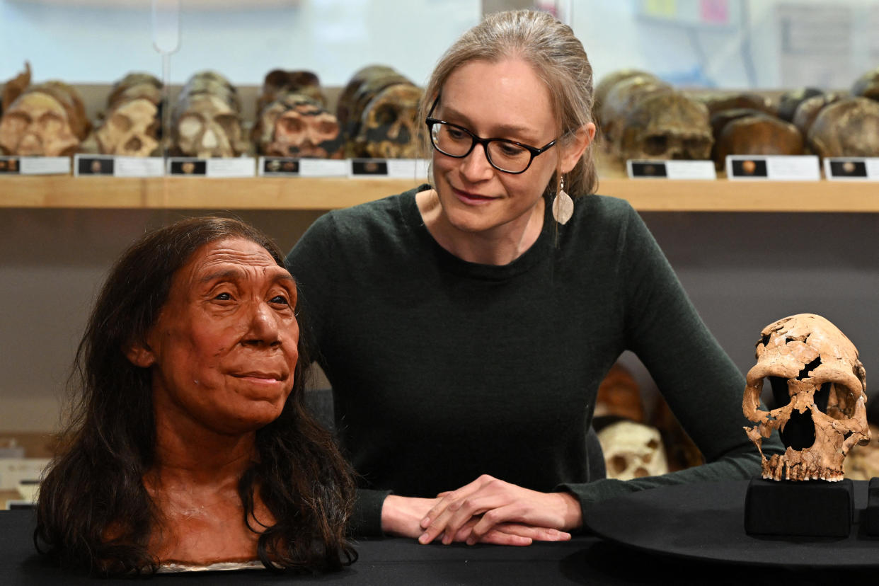 Associate Professor in the Evolution of Health, Diet and Disease, Dr Emma Pomeroy, poses for a photograph with the rebuilt skull and a physical reconstruction of the face and head, of a 75,000-year-old Neanderthal woman, named Shanidar Z, at the University of Cambridge, eastern England, on April 25, 2024. / Credit: JUSTIN TALLIS/AFP via Getty Images