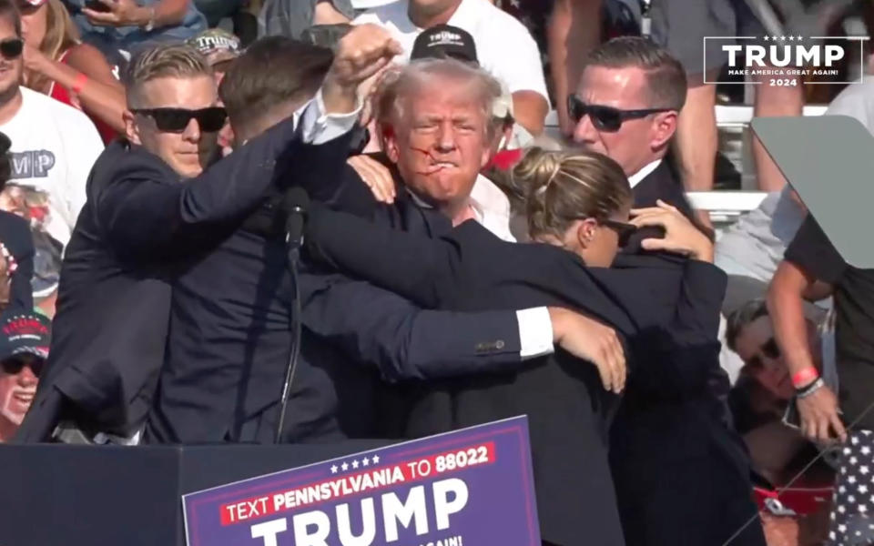 BUTLER, PENNSYLVANIA, UNITED STATES - JULY 13: (----EDITORIAL USE ONLY - MANDATORY CREDIT - 'TRUMP CAMPAIGN OFFICE / HANDOUT' - NO MARKETING NO ADVERTISING CAMPAIGNS - DISTRIBUTED AS A SERVICE TO CLIENTS----) A screen grab captured from a video shows Republican presidential candidate former President Donald Trump appears to be injured after gunshots were reported as he is rushed offstage during a rally on July 13, 2024 in Butler, Pennsylvania. Trump was seen bloodied on his right ear as he was being evacuated from the stage, according to social media footage. (Photo by Trump Campaign Office / Handout/Anadolu via Getty Images)