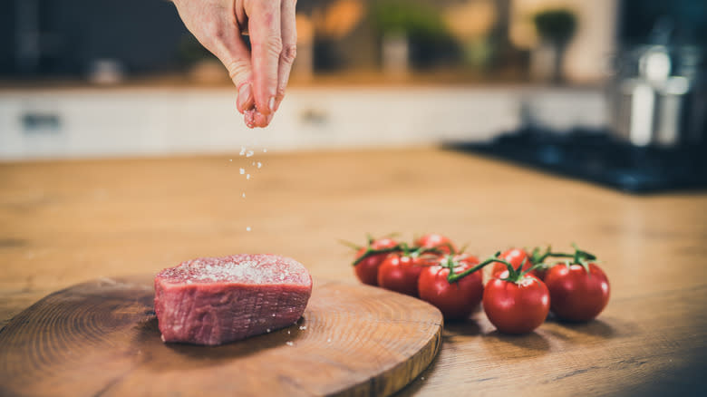 Person seasoning steak