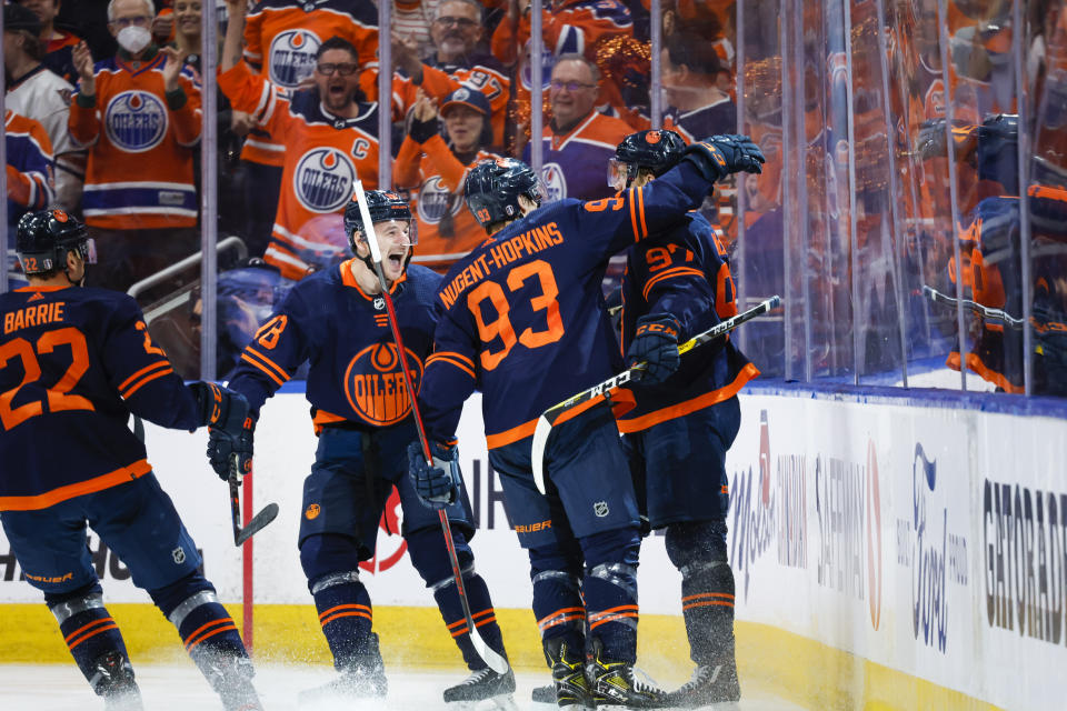 Edmonton Oilers center Connor McDavid, right, celebrates his goal with teammates left wing Zach Hyman, left, and center Ryan Nugent-Hopkins during the third period of Game 5 of an NHL hockey Stanley Cup first-round playoff series against the Los Angeles Kings, Tuesday, May 10, 2022 in Edmonton, Alberta. (Jeff McIntosh/The Canadian Press via AP)
