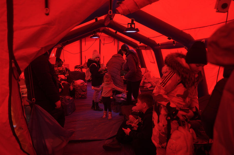 Children, who fled with others from Ukraine, play in a tent as they wait to be transferred in Budomierz, Poland, Monday, March 7, 2022. Russia's invasion of Ukraine has set off the largest mass migration in Europe in decades, with more than 1.5 million people having crossed from Ukraine into neighboring countries. (AP Photo/Markus Schreiber)