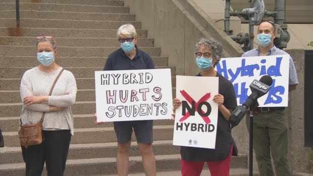 Parents, students and teachers gathered outside Toronto District School Board headquarters on Tuesday to demand an end to 'hybrid' classes in Toronto public schools. (CBC - image credit)