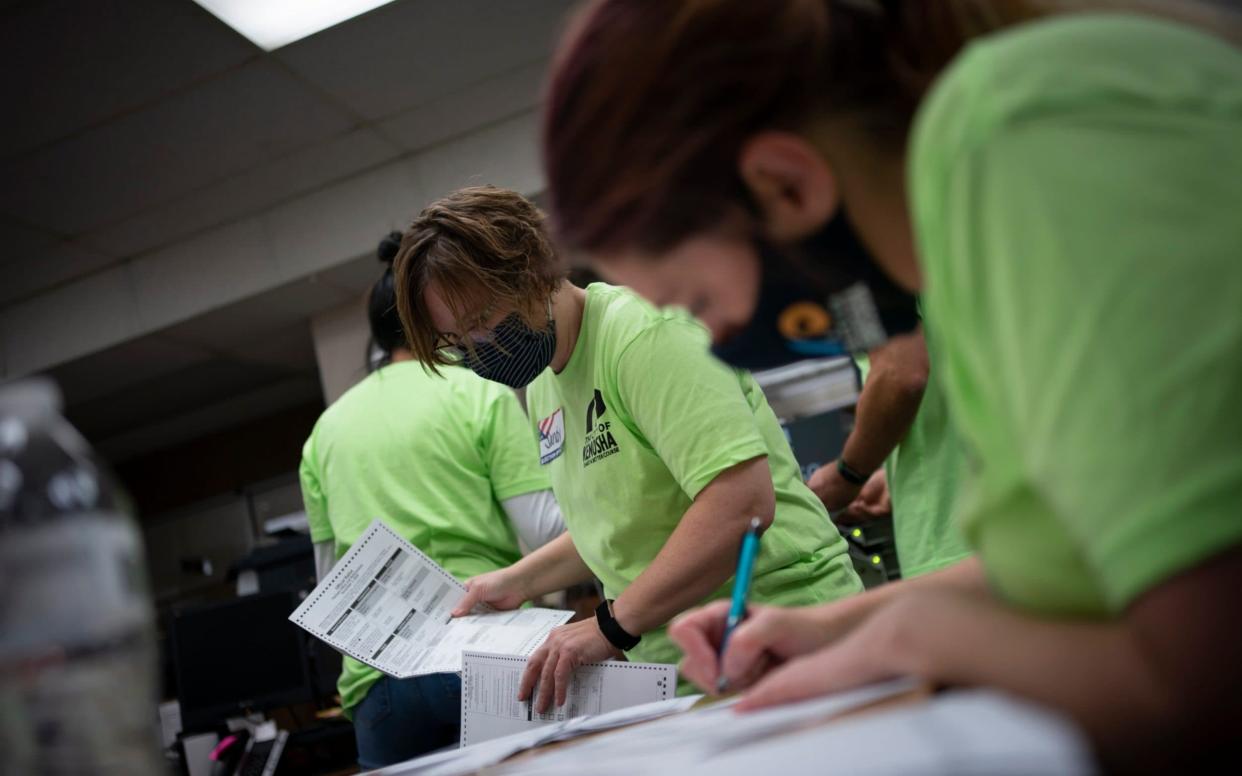 Poll workers sort out early and absentee ballots at the Kenosha Municipal building on Election Day - AP