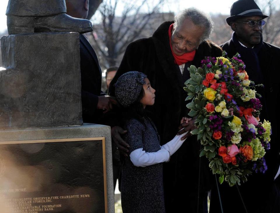 Hannah Hough, left, looks up at Sarah Stevenson after helping to place a wreath at the base of the Martin Luther King, Jr. statue during the annual Martin Luther King, Jr. Memorial at Marshall Park in uptown Charlotte on January 15, 2012. David T. Foster III/dtfoster@charlotteobserver.com