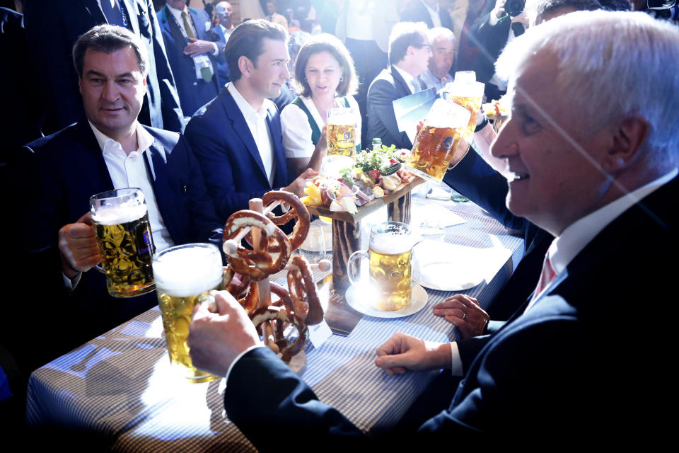 Austria's Federal Chancellor Sebastian Kurz, center, Bavarian State Governor Markus Soeder, left, and Horst Seehofer, Chairman of the Christian Social Union party (CSU), right, drink beer prior to a election campaign in Munich, Germany, Friday, Oct. 12, 2018. (AP Photo/Matthias Schrader)