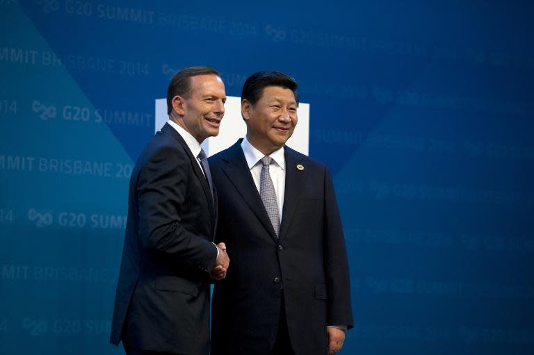 China&#39;s President Xi Jinping (R) is welcomed by Australia&#39;s Prime Minister Tony Abbott as he arrives to take part in the G20 Summit in Brisbane on November 15, 2014