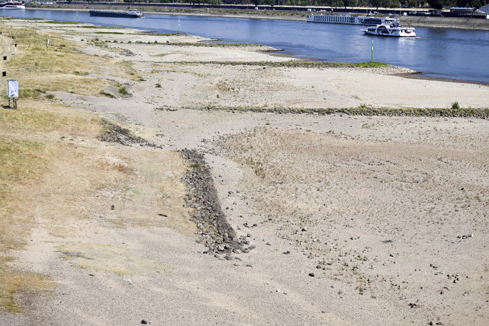 Ships sail past dry land in Dusseldorf, North Rhine-Westphalia, Germany. After weeks of drought, the water levels of the Rhine have reached historic lows. (Federico Gambarini/dpa via AP)