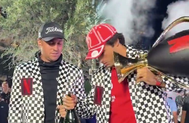 El español Carlos Sainz, ganador con el golfista estadounidense Justin Thomas, deja caer la copa, que se romperá en varias partes; ¿accidente o libreto?