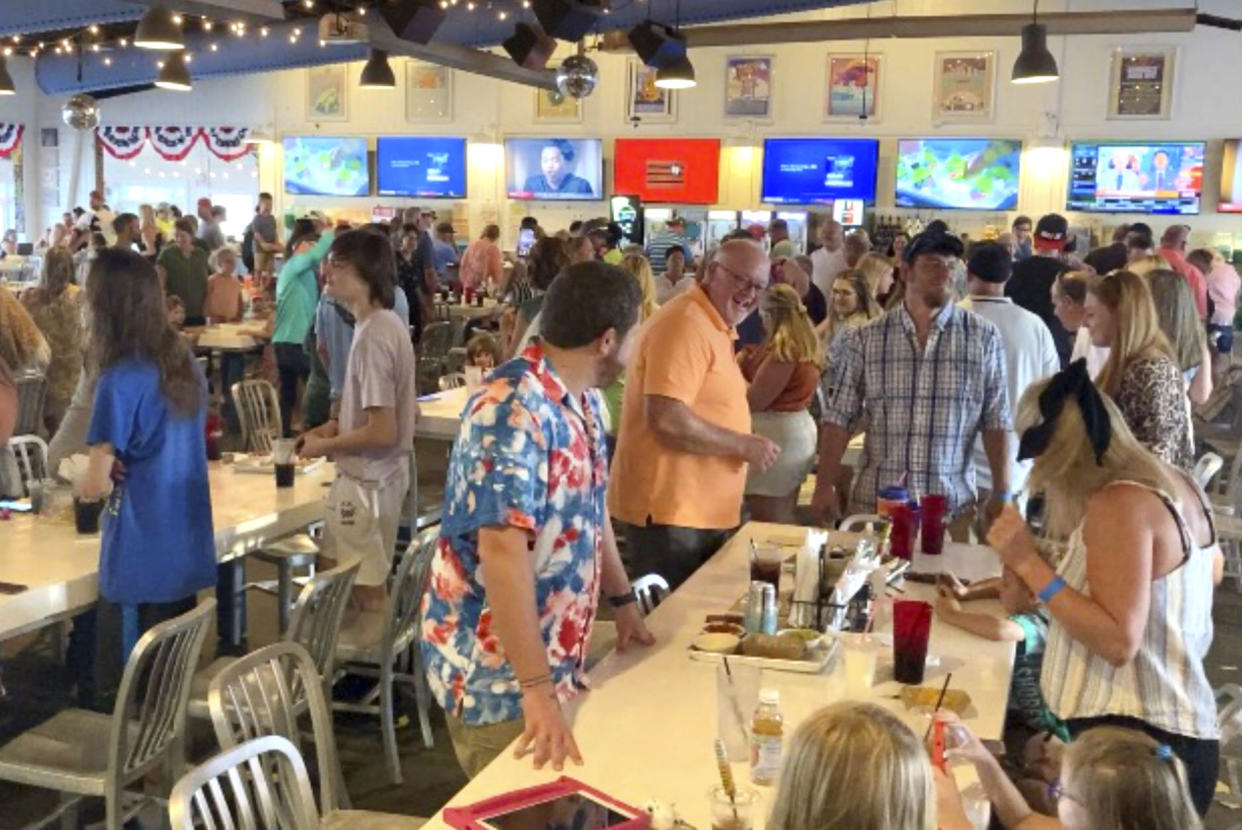 Customers dance inside The Hangout, a popular restaurant in Gulf Shores, Ala., on Thursday, Aug. 12, 2021. Alabama's coastal counties lead the state in new COVID-19 cases, and some events have been canceled in Florida and Louisiana because of the latest surge. Health officials believe the spike is due to a combination of some of the nation’s lowest vaccination rates, unabated tourism, a disregard for basic health precautions and the region’s carefree lifestyle. (AP Photo/Jay Reeves)