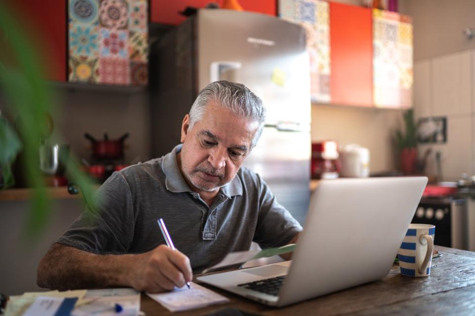 A person at a laptop takes notes.