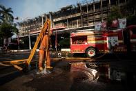 A firefighter holds a hose after putting out fire at the Attorney General's office in Jakarta