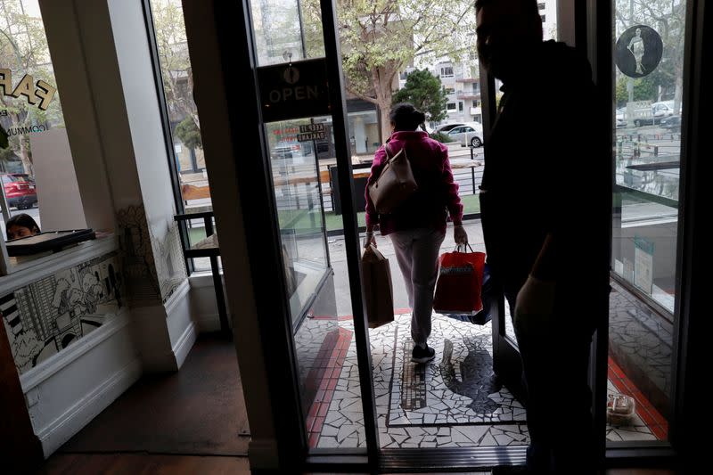 FILE PHOTO: An employee of Farley’s East cafe, that closed due to the financial crisis caused by the coronavirus disease (COVID-19), carries donated food items after being laid off from the cafe in Oakland