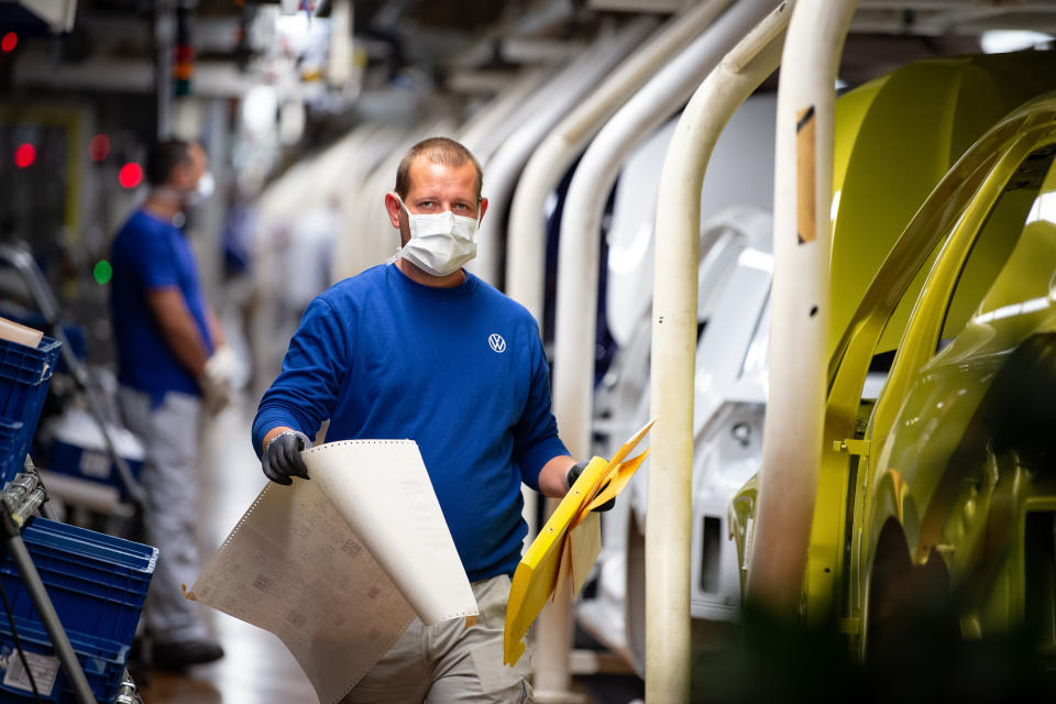 Volkswagen production line staff wear masks as they work at the Wolfsburg plant in Germany. (Swen Pförtner/Getty Images)