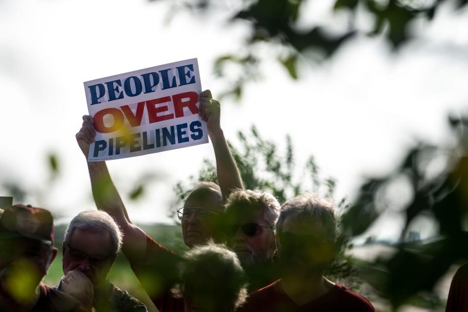 Landowners hold signs during a press conference by opponents of the Summit Carbon Solutions pipeline on Tuesday, August 22, 2023 in Fort Dodge.