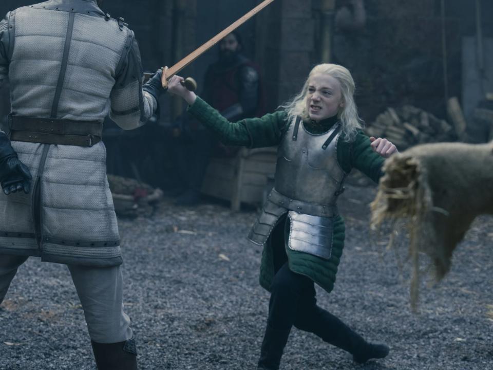 A young boy wearing a green tunic under silver armor.